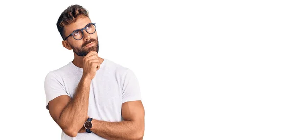 Mladý Hispánec Neformálním Oblečení Brýlích Rukou Bradě Přemýšlí Otázce Zamyšleném — Stock fotografie