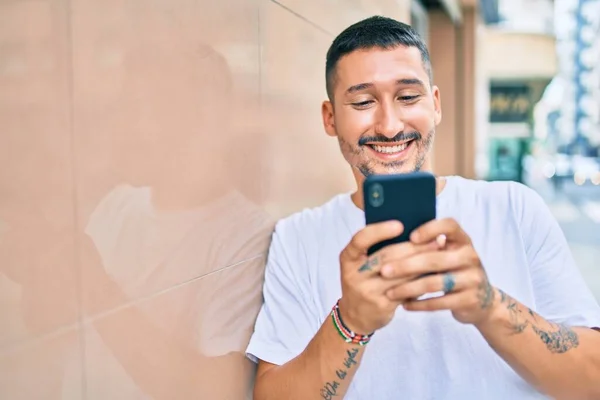 Junger Hispanischer Mann Lächelt Glücklich Mit Smartphone Die Wand Gelehnt — Stockfoto