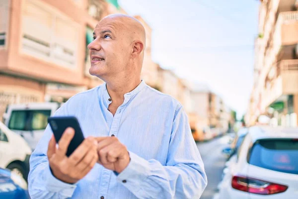 Middelbare Leeftijd Kale Man Glimlachend Gelukkig Met Behulp Van Smartphone — Stockfoto