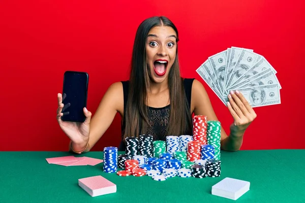 Νεαρή Ισπανόφωνη Γυναίκα Που Παίζει Πόκερ Κρατώντας Smartphone Και Δολάρια — Φωτογραφία Αρχείου
