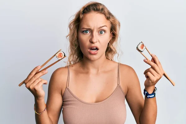 Mulher Branca Bonita Comendo Sushi Usando Pauzinhos Rosto Choque Parecendo — Fotografia de Stock