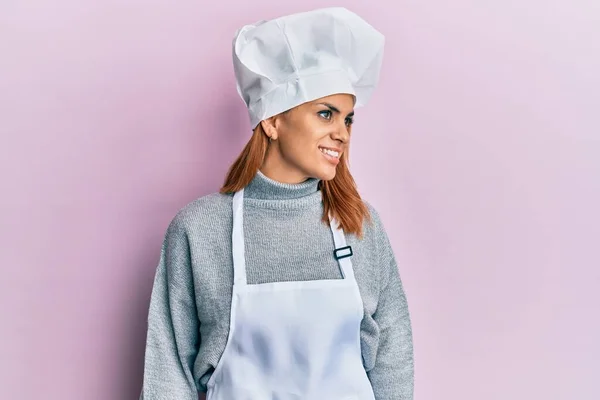 西班牙裔年轻女子身穿职业厨师制服 头戴帽子 面容自然 面带微笑 放松形象 — 图库照片