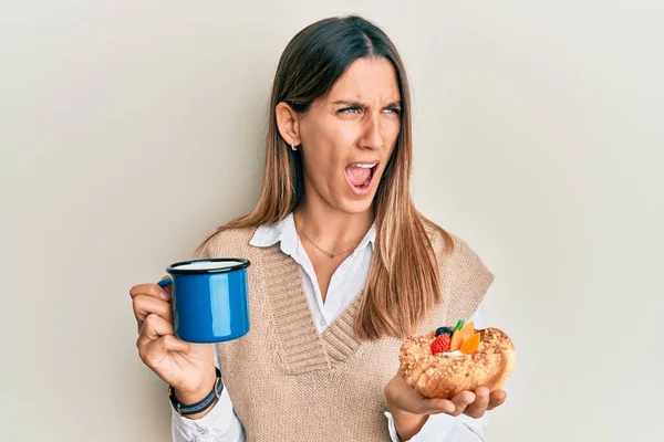 Morena Joven Bebiendo Café Comiendo Pastelería Enojada Loca Gritando Frustrada — Foto de Stock