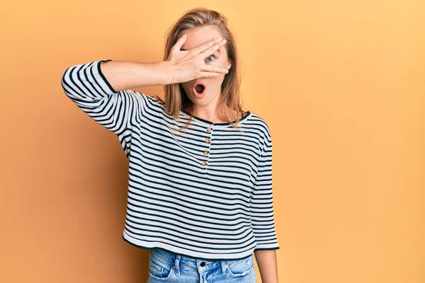 Mulher Loira Bonita Vestindo Roupas Casuais Espreitando Choque Cobrindo Rosto — Fotografia de Stock