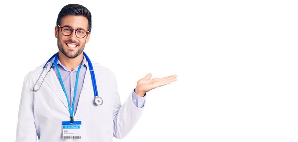 Joven Hispano Vistiendo Uniforme Médico Estetoscopio Sonriente Alegre Presentando Señalando —  Fotos de Stock