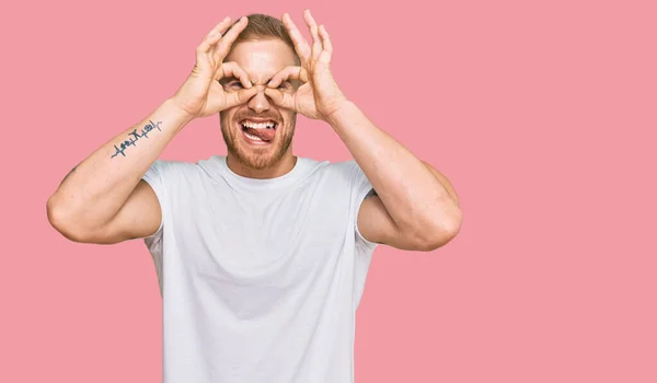 Young Irish Man Wearing Casual Clothes Doing Gesture Binoculars Sticking — Φωτογραφία Αρχείου