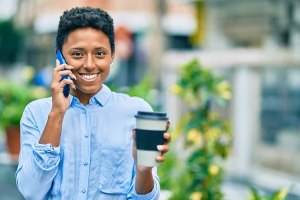 若いアフリカ系アメリカ人の女の子がスマートフォンで話して街でコーヒーを飲んで — ストック写真