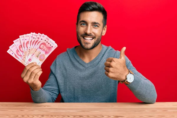 Hombre Hispano Guapo Sosteniendo Billetes Chinos Yuan Sonriendo Feliz Positivo —  Fotos de Stock