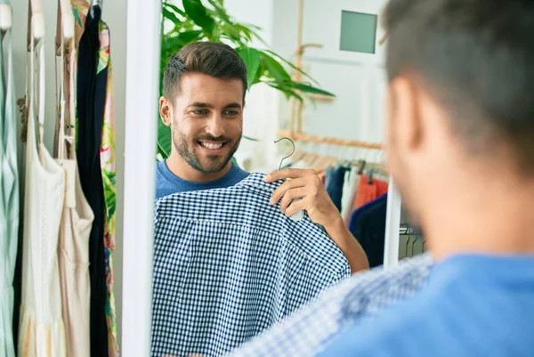 Joven Hombre Guapo Sonriendo Feliz Sosteniendo Ropa Tienda Ropa —  Fotos de Stock