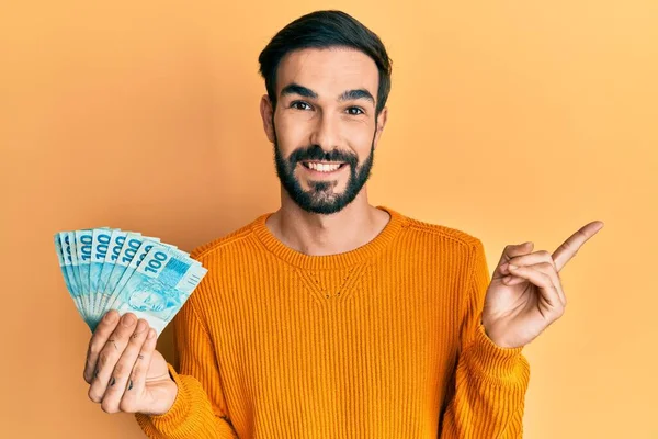 Joven Hombre Hispano Con Barba Sosteniendo 100 Billetes Reales Brasileños — Foto de Stock