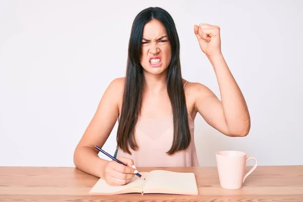 Jovem Caucasiana Sentada Mesa Escrevendo Livro Bebendo Café Irritado Frustrado — Fotografia de Stock