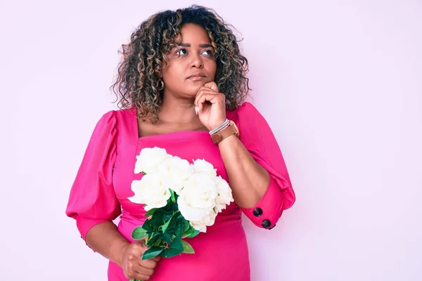 Jovem Afro Americana Size Mulher Segurando Flores Rosto Sério Pensando — Fotografia de Stock