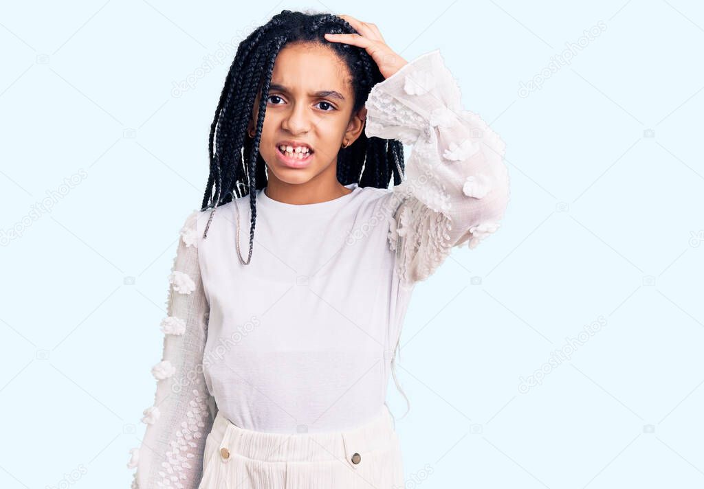 Cute african american girl wearing casual white tshirt confuse and wonder about question. uncertain with doubt, thinking with hand on head. pensive concept. 