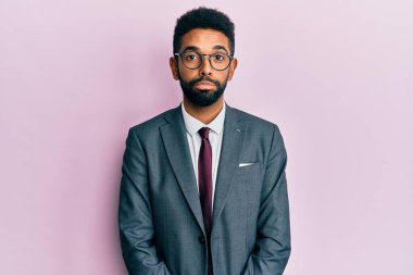 Yakışıklı, İspanyol takım elbiseli ve kravatlı genç bir adam elinle olumlu jest yapmayı onaylıyor, gülümsüyor ve başarı için seviniyor. kazanan jest. 