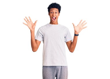 Genç afro-amerikan adam gündelik giysiler giyip çılgınlığı kutluyor ve başarıya hayret ediyor kolları açık ve gözleri açık heyecanla bağırıyor. Kazanan konsept 