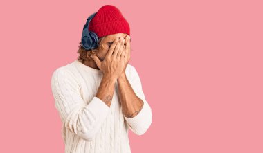 Genç İspanyol adam müzik dinlerken kulaklık takıyor ve ağlarken suratını ellerle kapatıyor. depresyon kavramı. 