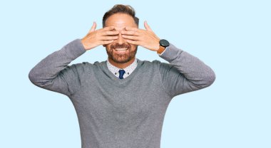 Yakışıklı, orta yaşlı, iş elbiseleri giyen, gözleri kapayan neşeli ve komik elleri olan bir adam. kör kavram. 