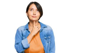 Kısa saçlı, kısa saçlı, genç, İspanyol bir kadın. Sıradan bir kot ceket giyiyor. Şüphe üzerine yoğunlaşmış. 