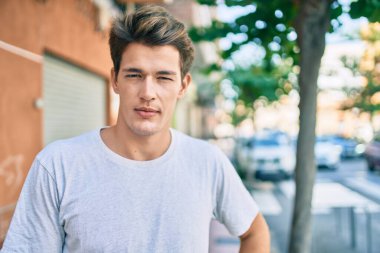 Yüzünde ciddi bir ifade olan beyaz bir genç şehre doğru yürüyordu..