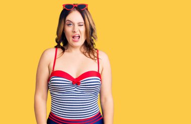 Mayo giyen güzel beyaz bir kadın kameraya seksi bir ifadeyle bakıyor, neşeli ve mutlu bir yüzle.. 