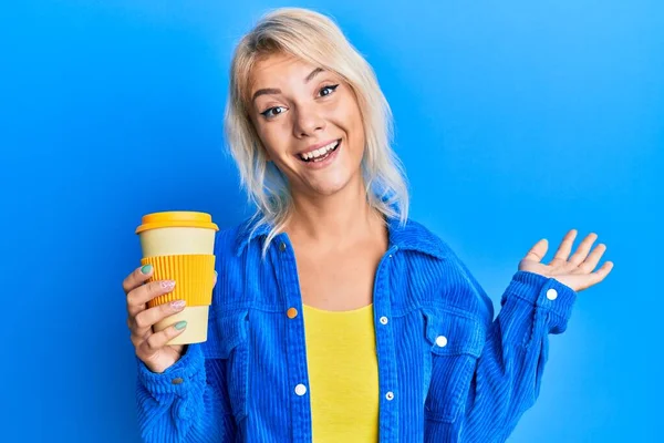 Menina Loira Jovem Segurando Tirar Café Celebrando Realização Com Sorriso — Fotografia de Stock