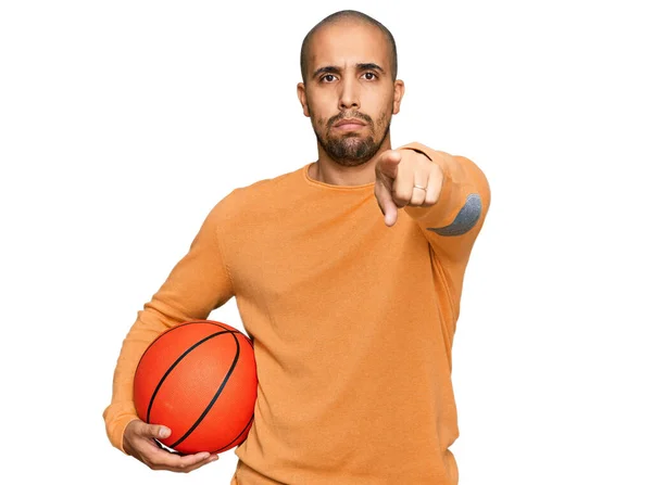 Hispanischer Erwachsener Mann Hält Basketballball Und Zeigt Mit Dem Finger — Stockfoto