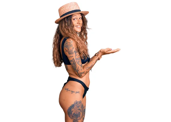 Молодая Латиноамериканка Татуировкой Бикини Летняя Шляпа Указывающая Сторону Открытыми Руками — стоковое фото