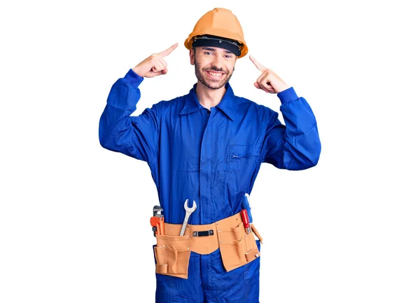 Jovem Hispânico Vestindo Uniforme Trabalhador Sorrindo Apontando Para Cabeça Com — Fotografia de Stock