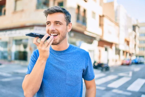 若い白人男性笑顔幸せな送信音声メッセージを使用してスマートフォンで市内 — ストック写真