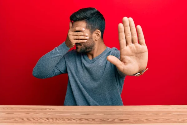 Snygg Latinamerikansk Man Klädd Avslappnad Stil Sitter Bordet Täcker Ögon — Stockfoto