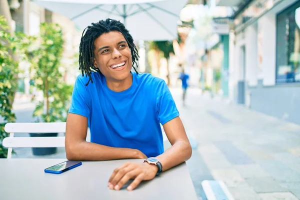 Νεαρός Αφροαμερικάνος Χαμογελώντας Χαρούμενος Χρησιμοποιώντας Smartphone Κάθεται Στο Τραπέζι Στη — Φωτογραφία Αρχείου
