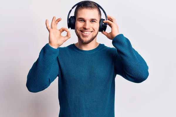 Jovem Homem Bonito Ouvindo Música Usando Fones Ouvido Fazendo Sinal — Fotografia de Stock