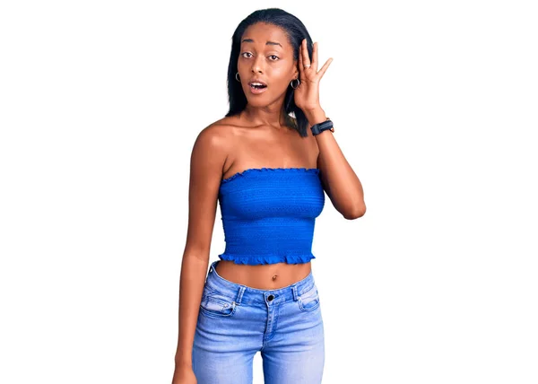 年轻的非洲裔美国女人穿着休闲夏装 面带微笑 侧耳倾听谣言或流言蜚语 聋的概念 — 图库照片