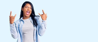 Uzun saçlı, sıradan kot ceket giyen, çılgın bir ifadeyle bağıran, elleri havada rock sembolü yapan İspanyol bir kadın. Müzik yıldızı. ağır kavram. 