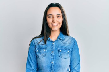 Sıradan kot ceket giyen genç İspanyol kadın el hareketleriyle gülümsüyor, mutlu yüzüyle parmaklarından bakıyor.. 