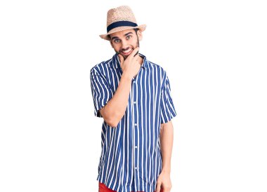 Sakallı, yaz şapkalı ve çizgili gömlekli genç yakışıklı. Kameraya kendinden emin bakıyor. Kollarını kavuşturup, çenesini kaldırmış gülümsüyor. Olumlu düşünmek. 