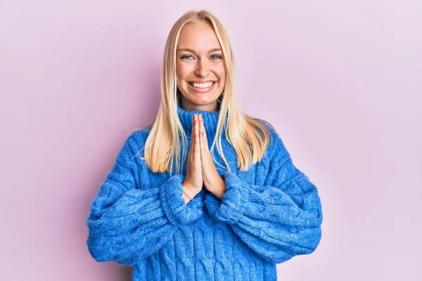 스웨터를 모으고 기도하는 소녀는 자신감을 가지고 웃으며 용서를 구합니다 — 스톡 사진