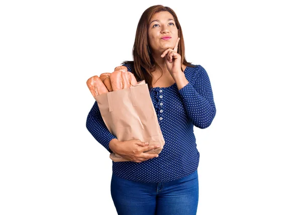 Middle Age Latin Woman Holding Paper Bag Bread Serious Face — 스톡 사진