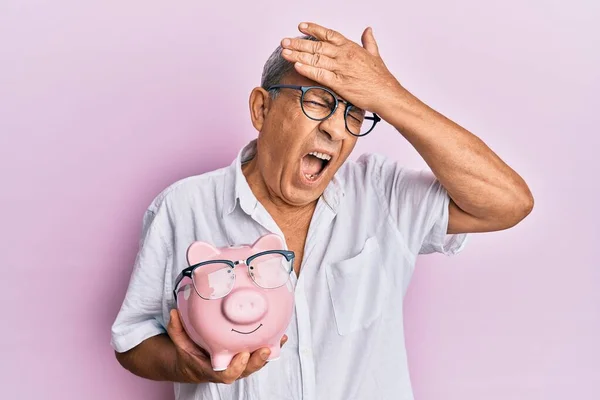 Przystojny Dojrzały Senior Trzymający Skarbonkę Okularach Zestresowany Sfrustrowany Ręką Głowie — Zdjęcie stockowe