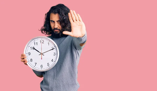 Hombre Árabe Joven Sosteniendo Gran Reloj Con Mano Abierta Haciendo —  Fotos de Stock