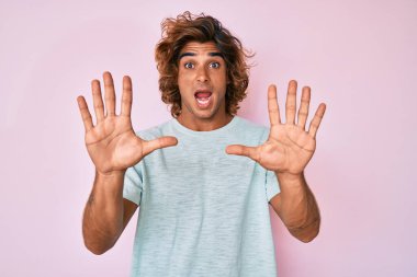 Günlük giysiler giyen genç İspanyol adam korku ifadesinden korkuyor ve dehşete düşüyor. El hareketlerini durdur, şok içinde bağır. panik konsepti. 