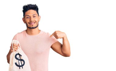 Yakışıklı Latin Amerikalı genç adam para çantası tutuyor dolar sembolü ile kendini gösteren mutlu ve gururlu bir gülümseme 