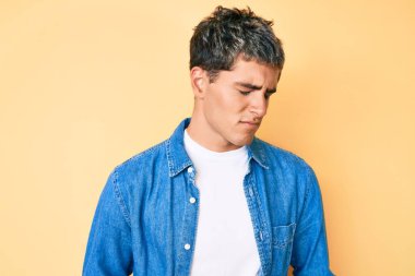 Genç ve yakışıklı bir adam midesi üstünde sıradan kıyafetler giyiyor çünkü hazımsızlık, acı verici bir hastalık ve kendini iyi hissetmiyor. Ağrı kavramı. 