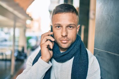 Kafkasyalı, rahat yüzlü, şehirdeki akıllı telefondan konuşan genç bir adam..