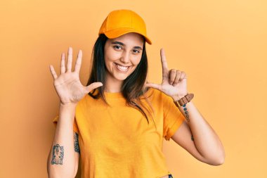 Teslimat üniforması giyen, şapkalı, elleri göğsünde, gözleri kapalı gülümseyen ve yüzünde minnet ifadesi olan İspanyol bir kadın. sağlık kavramı. 