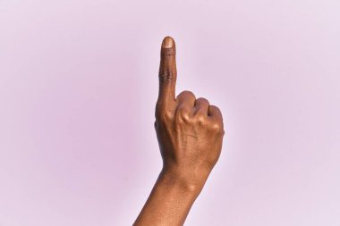 Pembe izole edilmiş arka plan üzerinde orta yaşlı bir kadının kolu ve eli işaret parmağı kullanarak bir numarayı sayıyor, fikir ve anlayış gösteriyor. 