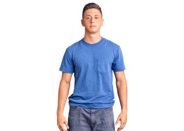 Yüzünde ciddi bir ifade olan gündelik kıyafetler giyen yakışıklı İspanyol bir adam. Basit ve doğal bir şekilde kameraya bakıyorsun.. 