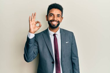 Yakışıklı İspanyol takım elbiseli ve kravatlı genç adam. Başarı için heyecanlı kolları havada ve gözleri kapalı zaferi kutlarken gülümsüyor. Kazanan konsept. 