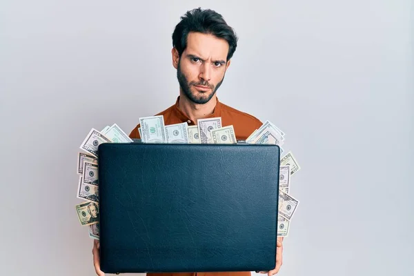 Young Hispanic Man Holding Briefcase Dollars Skeptic Nervous Frowning Upset — Stock Photo, Image