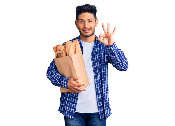 Красивый Латинский Американский Молодой Человек Держит Бумажный Пакет Хлебом Улыбаясь — стоковое фото